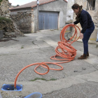 Una vecina de Fuentes muestra el sistema de suministro de agua con una manguera-V.G.