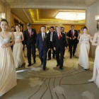 Wang, Cerezo y Gil llegan a la ceremonia de la firma rodeados de elegantes azafatas.-Foto:   JASON LEE / REUTERS