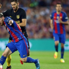 Messi disputa un balón con Carrasco en el Camp Nou antes de lesionarse.-EFE / TONI ALBIR