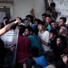 La policía helena carga contra los inmigrantes que esperan para registrarse en el puerto de Mitelene, en la isla de Lesbos.-AFP / ANGELOS TZORTZINIS