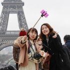 Un grupo de turistas orientales ante la Torre Eiffel.-