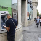 Usuarios de un cajero de Bankia en plaza Catalunya de Barcelona.-ÁLVARO MONGE