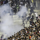 Los aficionados de Vasco da Gama se enfrentan con la policía durante el partido de su equipo contra el Flamengo.-EFE / ANTONIO LACERDA