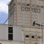 Un bombero trabajando en el tejado de una de las naves de Copiso tras la explosión. / V. GUISANDE-