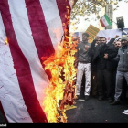 Manifestantes queman la bandera.-REUTERS