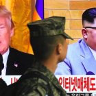 Un soldado surcoreano pasa frente a un televisor en Seúl mientras aparecen en la pantalla Donald Trump y Kim Jong un.-/ AFP / JUNG YEON-JE