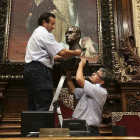 Dos operarios retiran el busto del rey Juan Carlos del salón de plenos del Ayuntamiento de Barcelona.-Foto: DANNY CAMINAL