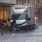 Gente corre para refugiarse de la tormenta de agua y granizo de este miércoles en Soria. MARIO TEJEDOR