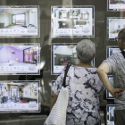 Una pareja mira pisos de alquiler en una inmobiliaria de Barcelona.-JOAN CORTADELLAS