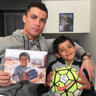 Cristiano Ronaldo ha subido en sus cuentas de Facebook e Instagram una imagen junto a su hijo en la que sostiene una foto de un pequeño sirio.-