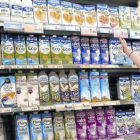 Una clienta elige leche entre la gran variedad de oferta del supermercado.-RICARD CUGAT