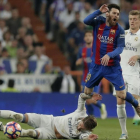 Sergio Ramos, en el suelo delante de Messi, en el clásico del pasado mes de abril.-AP / DANIEL OCHOA DE OLZA