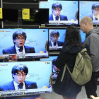 Seguimiento en una tienda de Bacelona de la rueda de prensa de Puigdemont en Bruselas el pasado 31 de octubre.-/ FERRAN NADEU