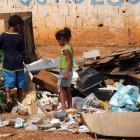 Dos niños buscan entre la basura en Brasilia, Brasil.-EFE/Archivo