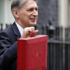El ministro de Finanzas británico, Philip Hammond, posa con el tradicional maletín rojo del presupuesto.-/ AP / FRANK AUGSTEIN