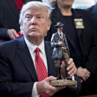 Trump sostiene una figura con la que fue obsequiado en la reunión que mantuvo ayer con los 'sheriffs' del país.-ANDREW HARRER