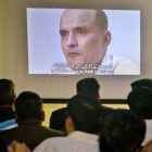 Unos periodistas observan la imagen de Jadhav mientras el portavoz del ejército paquistaní explcia su condena.-ANJUM NAVEED