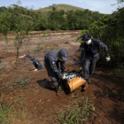 Bomberos cargan uno de los cadáveres recuperados el 12 de noviembre tras la rotura de la represa de la mina de hierro.-REUTERS / RICARDO MORAES