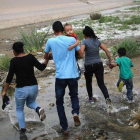 Una familia de inmigrantes cruzan de manera ilegal la frontera entre México y los EEUU. / MARIO TAMA (AFP)-AFP / MARIO TAMA