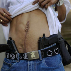 Un traficante de drogas muestra su herida de bala y su arma en Caracas.-Rodrigo Abd / AP