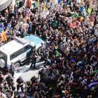 Decenas de personas intentan impedir que salga el coche de la Guardia Civil tras el registro al Departament dAfers Exteriors de la Generalitat.-FERRAN NADEU