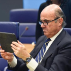 Luis de Guindos mira su tableta durante una reunión del Eurogrupo celebrada en Luxemburgo.-AFP
