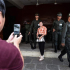 Una turista se fotografía con unos soldados en Bangkok, Tailandia.-AFP / LILLIAN SUWANRUMPHA