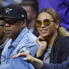El rapero Jay Z (izq) y su esposa, la cantante Beyonce, asisten a un partido de la NBA.-AP