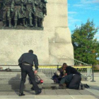 Unos soldados atienden a un compañero herido, ante el monumento de los veteranos de guerra en Ottawa.-Foto: EL PERIÓDICO