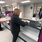 Una clienta realiza una gestión en una oficina bancaria en Tona (Osona).-JOSEP GARCIA