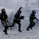 Policías lanzan botes de gas lacrimógeno contra los manifestantes que les lanzaron piedras y latas en las inmediaciones del Congreso, en Buenos Aires, el 14 de diciembre.-AP / NATACHA PISARENKO