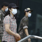 Soldados y civiles pasean con mascarillas por las calles de Seúl.-Foto: EFE