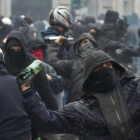 Manifiestantes antisistema lanzan botellas contra la policía italiana en Milán.-Foto: AP / DANIEL DAL ZENARO