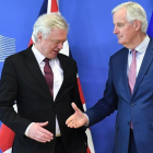 Michel Barnier tiende la mano a David Davis en la sede de la Comisión Europea, en Bruselas.-AFP