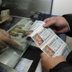 Un hombre compra tres décimos de lotería en una administración de Soria. / VALENTÍN GUISANDE-