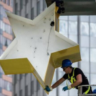 Un operario trabaja en la escultura del logo del euro ante la anterior sede del BCE en Francfort.-AFP / BORIS ROESSLER