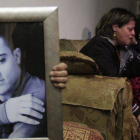 La madre del presunto espía asesinado por el EI llora junto a un retrato de éste en su casa en Jerusalén.-Foto: EFE / STR
