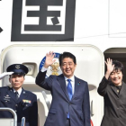 Abe (segundo por la izquierda) y su esposa, Akie, saludan antes de embarcarse en el avión hacia EEUU, en el aeropuerto de Haneda (Tokio), este jueves.-AFP / KAZUHIRO NOGI