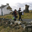 Dos oficiales se llevan la urna de la isla irlandesa de Inishbofin.-REUTERS / DARREN STAPLES