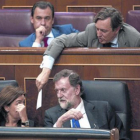 Mariano Rajoy y Soraya Sáenz de Santamaría hablan en el banco azul mientras Rafael Hernando les pasa una nota.-DAVID CASTRO