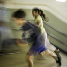Dos niños corren a la entrada del colegio.