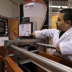 Un trabajador de la empresa Gerionte Technology muestra la máquina de alimentación automática para las cerdas gestantes.-ENRIQUE CARRASCAL
