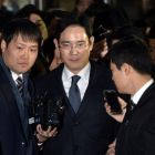 El heredero de Samsung, Lee Jae-Yong (centro), abandona el tribunal que ha ordenado su arresto, este viernes en Seúl.-AFP / YONHAP