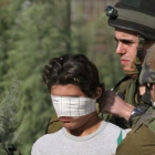 Un soldado israelí venda los ojos de un detenido palestino cerca de Nablus, en Cisjordania.-AP / NASSER ISHTAYEH