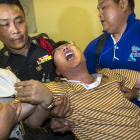 Un ciudadano chino que perdió a su mujer y a su hija en el atentado llora desconsolado en el Instituto de Medicina Forense de Bangkok.-Foto:   REUTERS / ATHIT PERAWONGMETHA