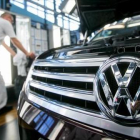 Un empleado de la Volkswagen de Dresde, junto a un Passat.-