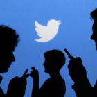 Siluetas de gente con el móvil, con el logo de Twitter al fondo.-Foto:   REUTERS / KACPER PEMPEL
