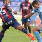 El jugador del Girona, Felipe Sanchón, trata de marcharse del defensa del Huesca, Carlos Akapo.-@GironaFC