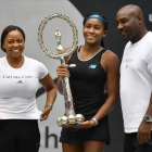 Gauff muestra feliz su primer trofeo junto a sus padres, en Linz.-