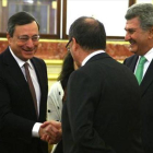 El presidente del BCE, Mario Draghi, saluda al gobernador del Banco de España, Luis María Linde.-AGUSTÍN CATALÁN